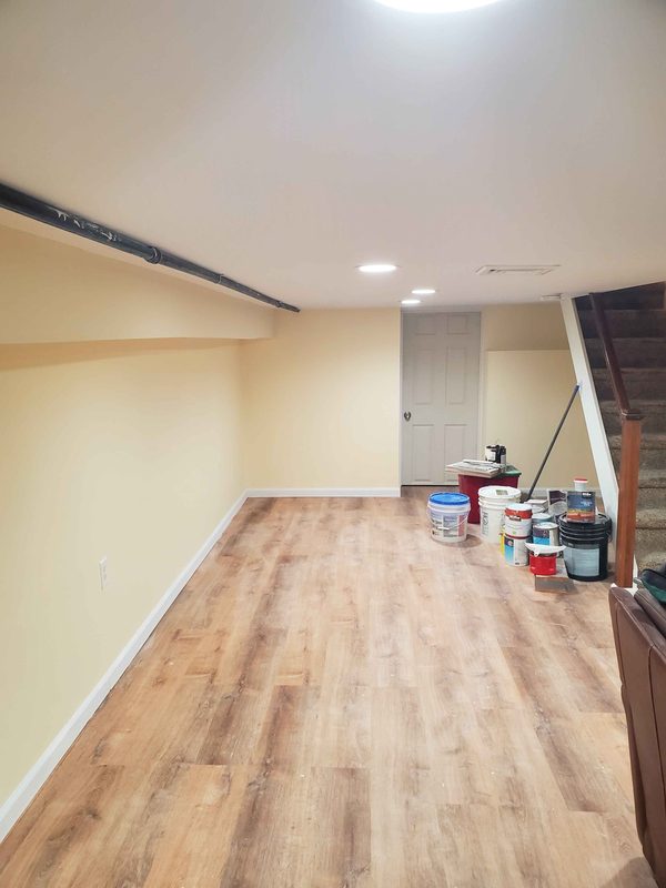 Finished basement: smooth painted walls, recessed lighting and wood-look plank flooring