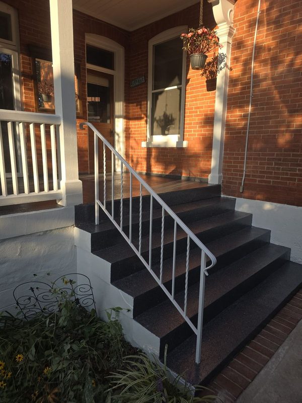 Finished front steps with a coated finish and metal railing